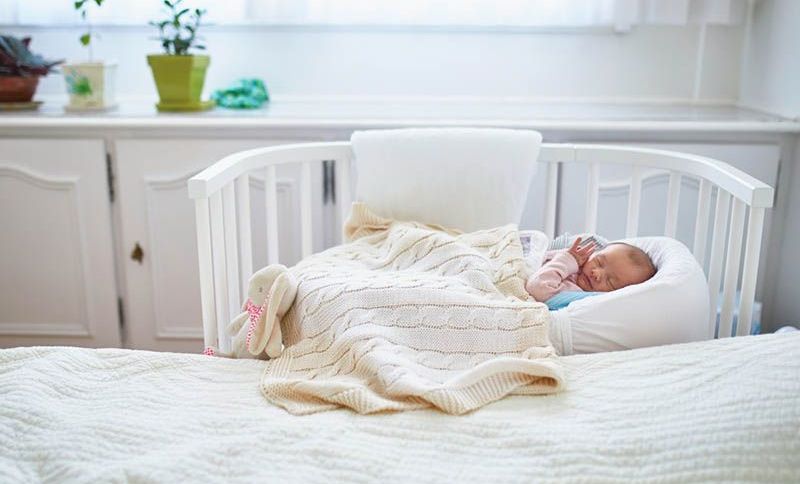 niedlichen neugeborenen Baby schlafen in einem Babybett im Schlafzimmer