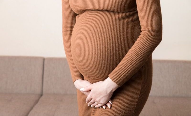 schwangere Frau, die ihren Unterkörper berührt