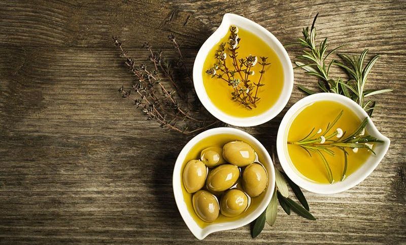 Olive in Öl und frische Kräuter auf Holztisch