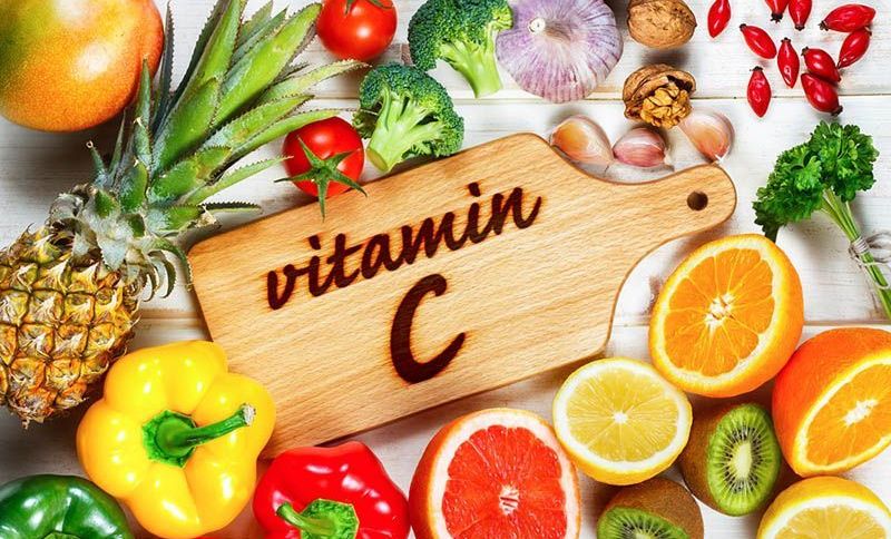 Lebensmittel, die Vitamin C enthalten und Schneidebrett mit Schild
