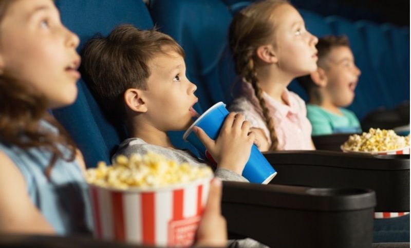 glückliche Kinder, die einen Film im Kino ansehen