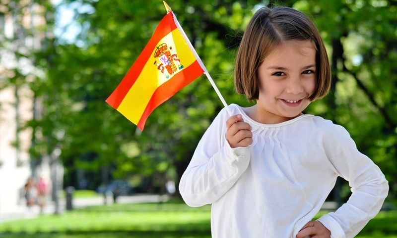 Junges Mädchen mit spanischer Flagge steht im Park